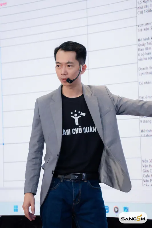 Hồ Đăng Sang đứng giảng bài trên sân khấu