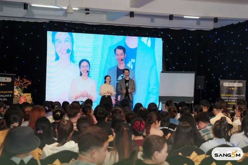 Hồ Đăng Sang cùng người dẫn chương trình trên sân khấu workshop Làm chủ quán, hội trường kín học viên