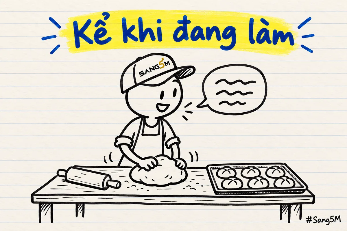 Tiệm bánh, người đội nón SANG5M vừa nặn bánh vừa nói, trên bàn có bột, cây cán bột và khay bánh, không có màn hình chữ.